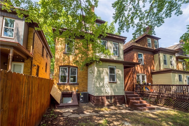 rear view of property with a deck and central AC unit