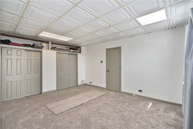 interior space with multiple closets and light colored carpet