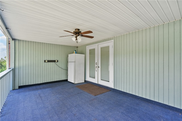 unfurnished sunroom featuring ceiling fan and french doors