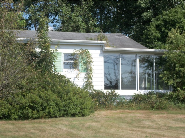 view of home's exterior featuring a yard and a sunroom