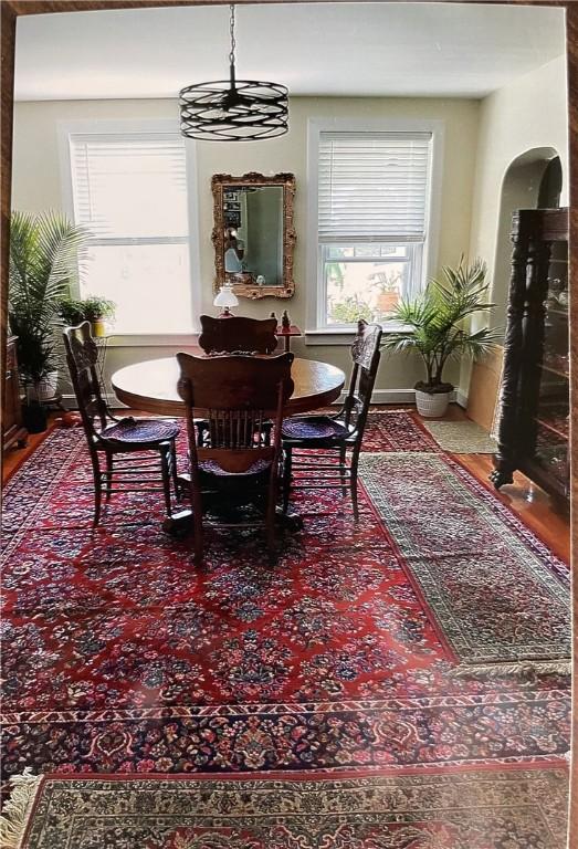 dining space featuring arched walkways and baseboards