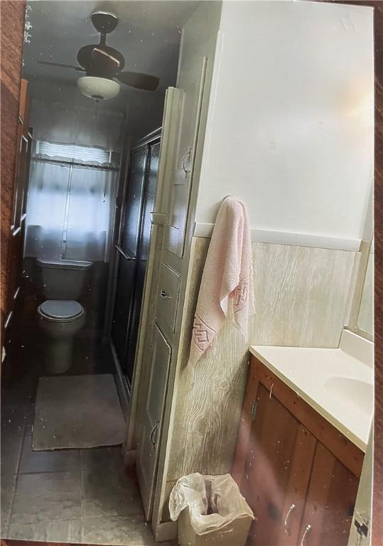 bathroom with vanity, ceiling fan, a stall shower, and toilet