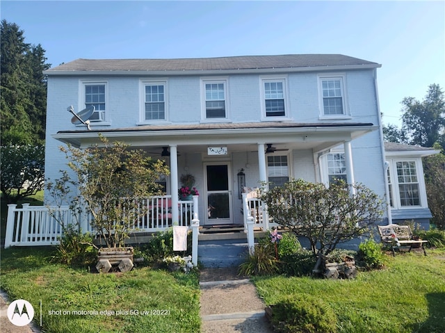 view of front facade with a front yard and covered porch