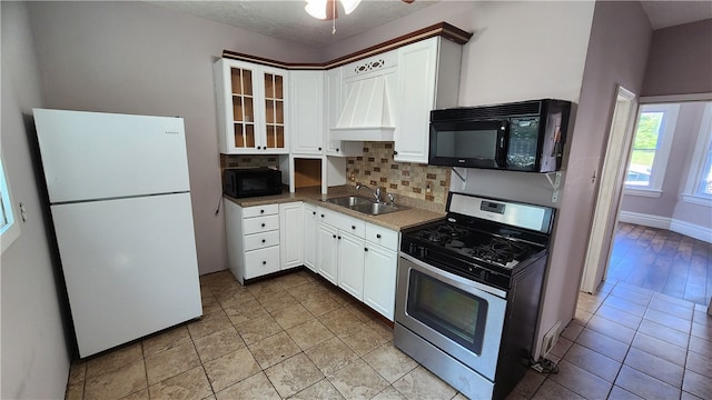 kitchen with white refrigerator, tasteful backsplash, ceiling fan, stainless steel range with gas cooktop, and sink