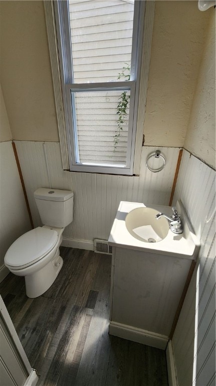 bathroom with vanity, toilet, and hardwood / wood-style floors