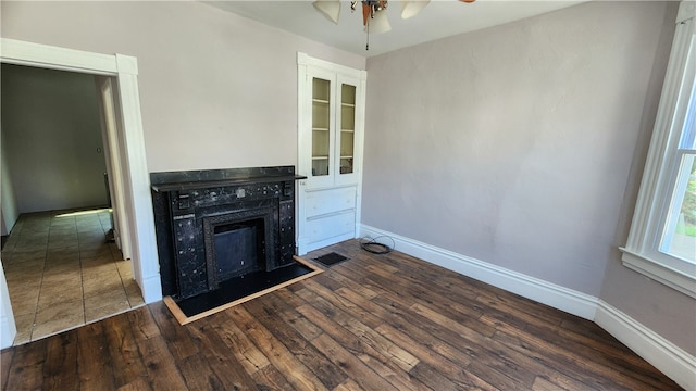 interior space with wood-type flooring, a high end fireplace, and ceiling fan