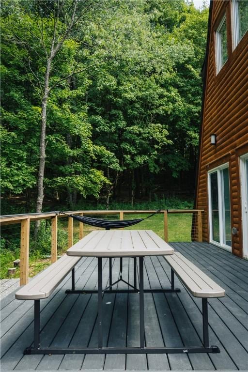 wooden terrace featuring a view of trees