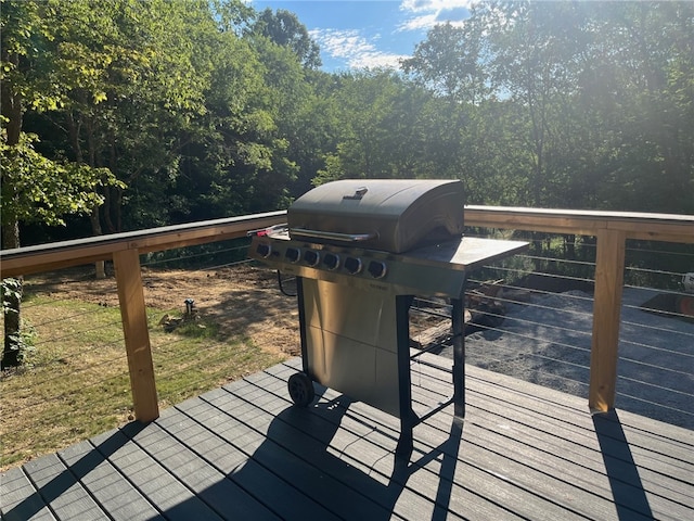 deck with a grill and a wooded view