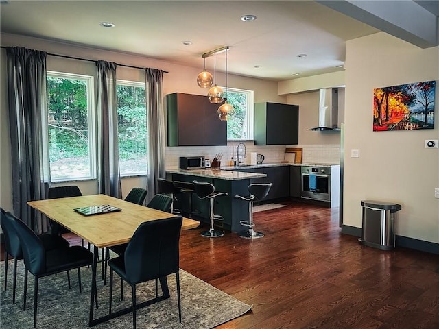 dining space featuring recessed lighting, dark wood finished floors, and baseboards