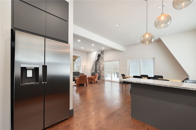 kitchen with recessed lighting, dark wood-type flooring, hanging light fixtures, stainless steel fridge with ice dispenser, and beamed ceiling