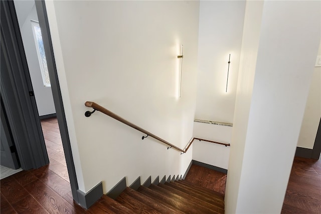 staircase with baseboards and wood finished floors