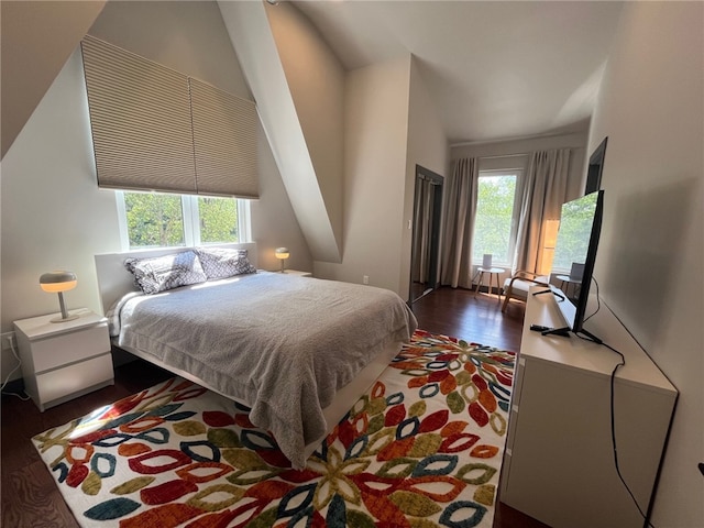 bedroom featuring dark wood-style floors and vaulted ceiling