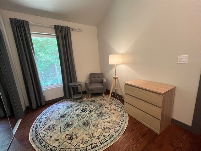 sitting room featuring vaulted ceiling, dark wood finished floors, and baseboards