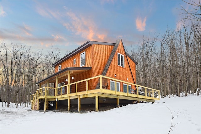 snow covered house with a deck