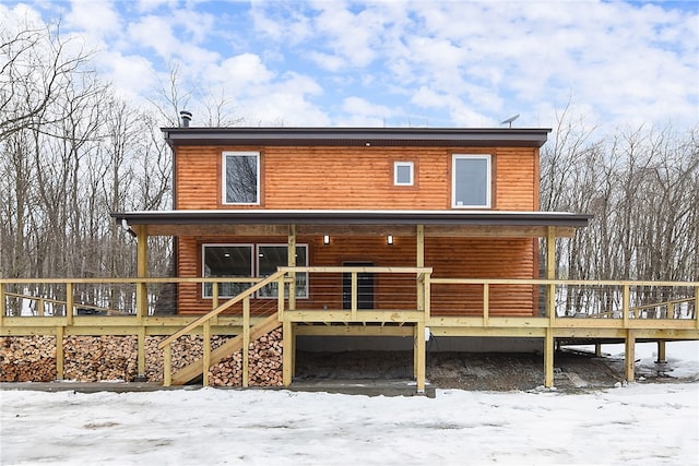 snow covered house with faux log siding