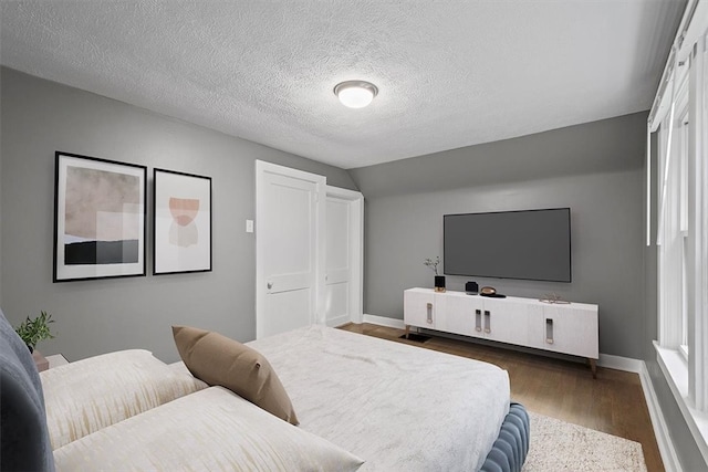 bedroom featuring a textured ceiling and dark hardwood / wood-style floors