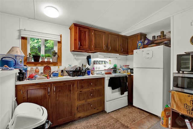 kitchen featuring lofted ceiling, white appliances, and light tile patterned floors