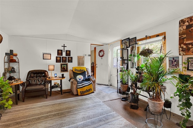 sitting room with lofted ceiling and light colored carpet