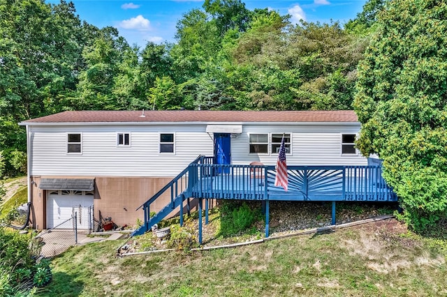 view of front facade with a garage, a deck, and a front lawn