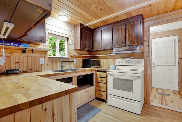 kitchen featuring wooden counters, wooden walls, white electric range oven, light hardwood / wood-style floors, and sink