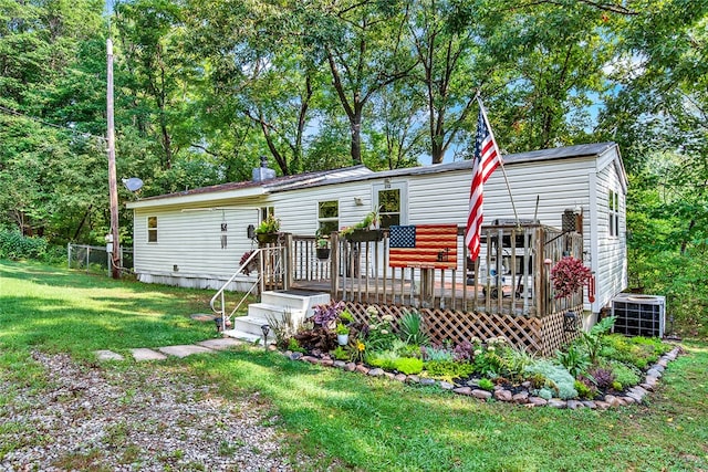 back of property with central AC, a deck, and a lawn