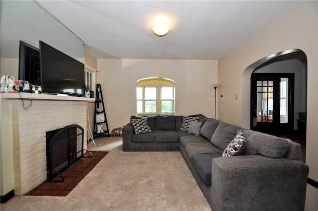 living room with a fireplace and dark colored carpet