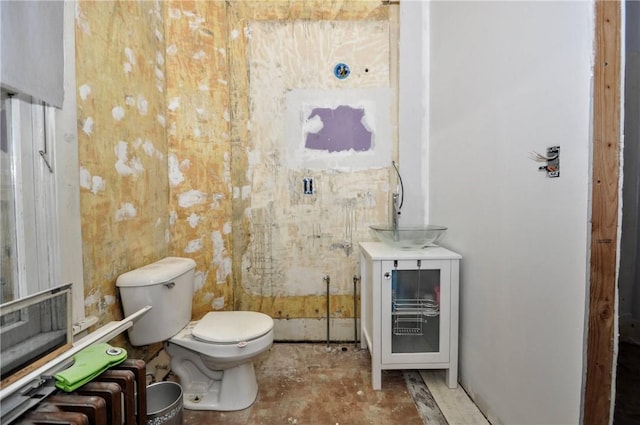 bathroom featuring toilet, radiator, and sink