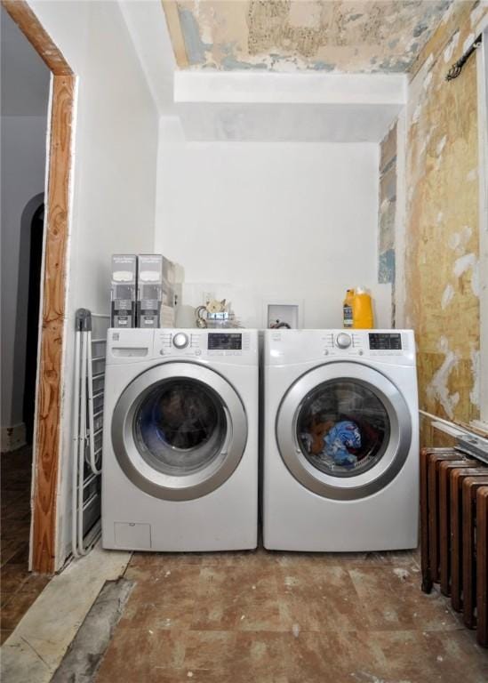 laundry area featuring radiator heating unit and washer and clothes dryer