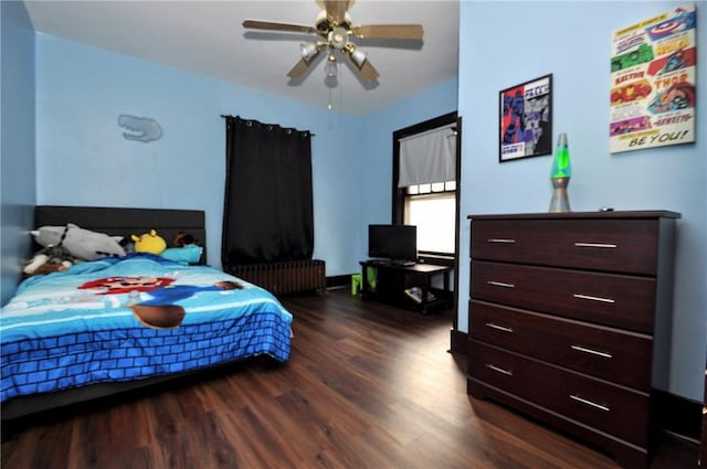 bedroom featuring dark wood-type flooring, radiator heating unit, and ceiling fan