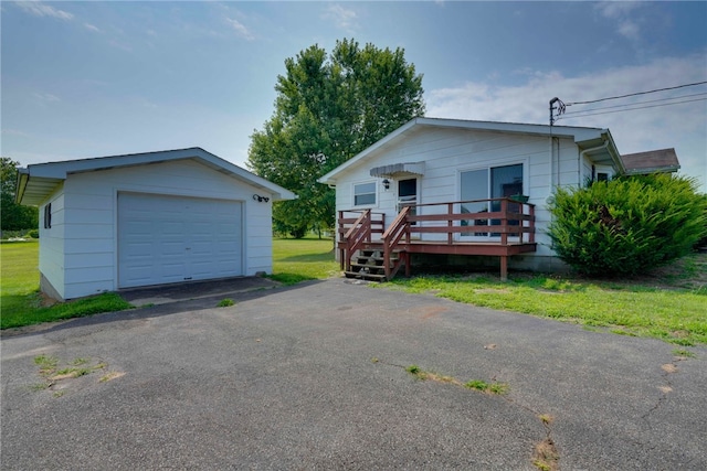 view of front of home featuring a garage, a front lawn, and an outdoor structure