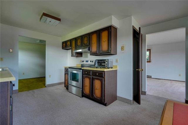 kitchen with stainless steel range with electric stovetop, dark brown cabinets, extractor fan, and light colored carpet