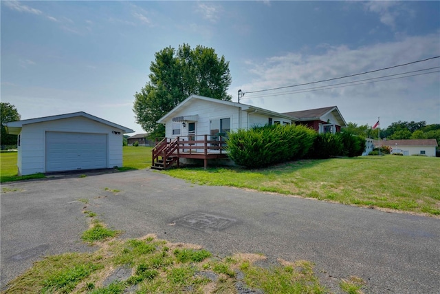 single story home featuring a garage, an outbuilding, a deck, and a front yard