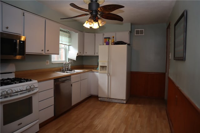 kitchen with appliances with stainless steel finishes, sink, light hardwood / wood-style flooring, and white cabinets