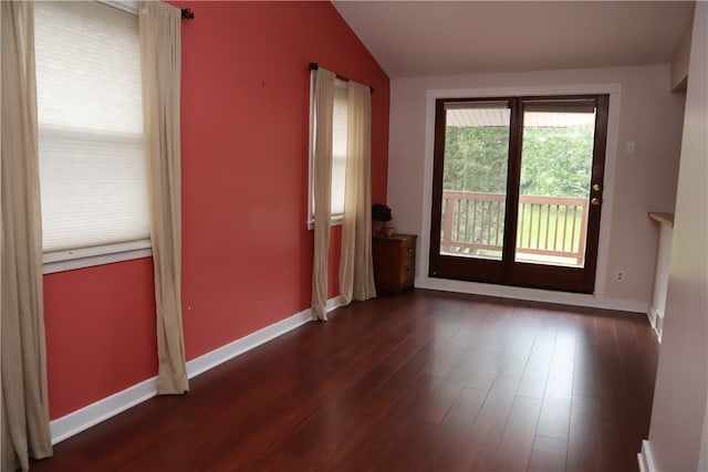 spare room with lofted ceiling and dark hardwood / wood-style flooring