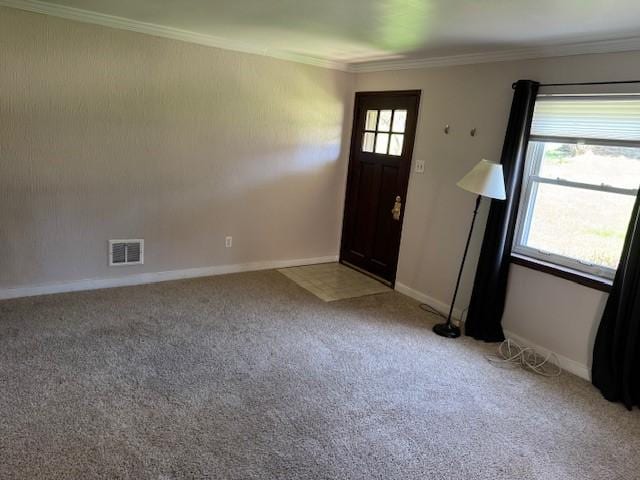 foyer entrance featuring light carpet, crown molding, and visible vents