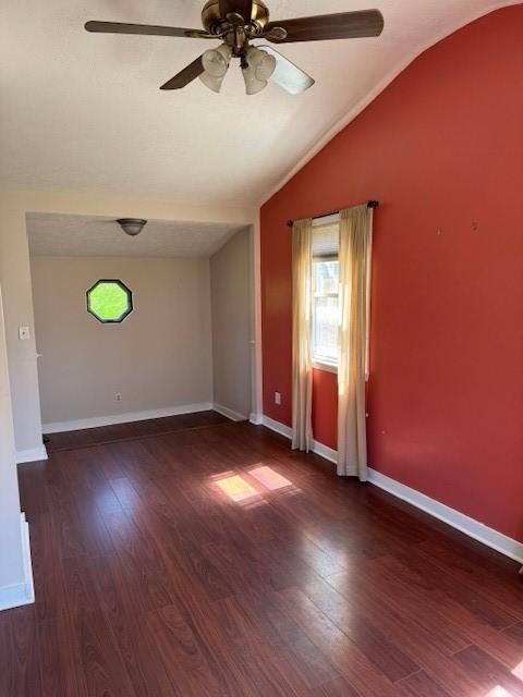 spare room with wood finished floors, a ceiling fan, lofted ceiling, and a wealth of natural light