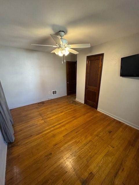 unfurnished bedroom featuring visible vents, a ceiling fan, and wood finished floors