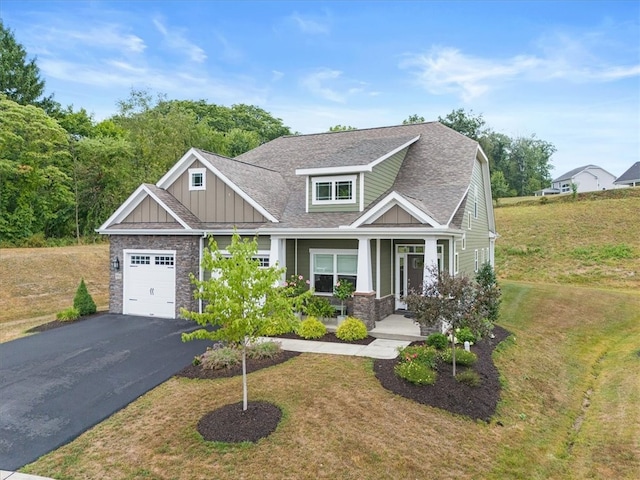 craftsman-style house with a garage, a front lawn, and covered porch