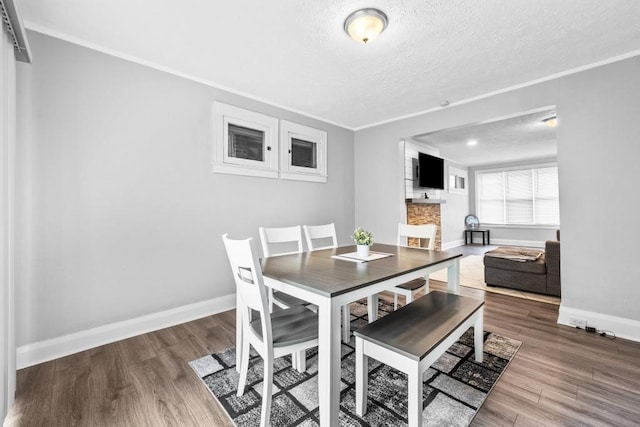 dining room featuring crown molding, a textured ceiling, and hardwood / wood-style flooring