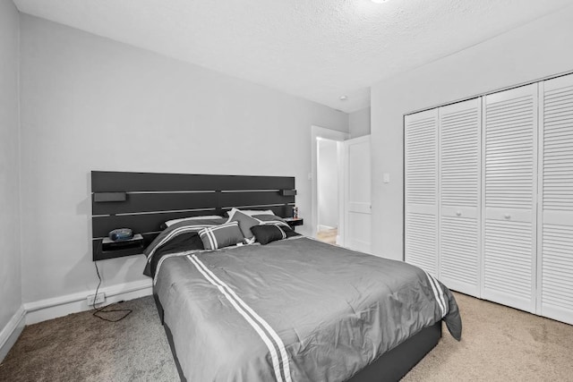 carpeted bedroom featuring a closet and a textured ceiling