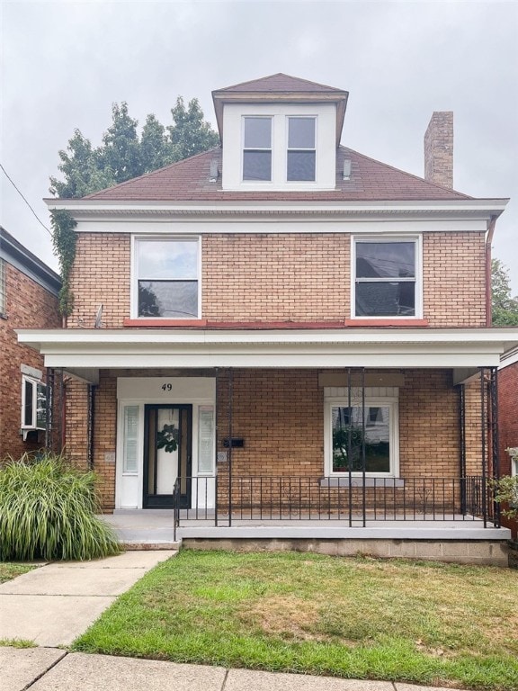 front facade with a porch and a front yard