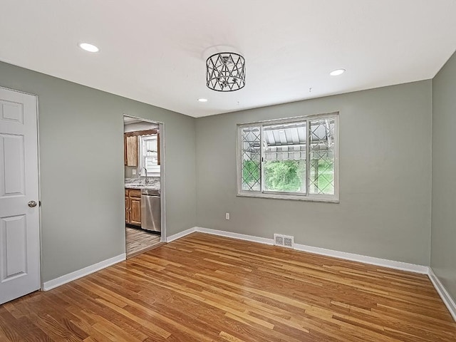 spare room with sink and light hardwood / wood-style floors