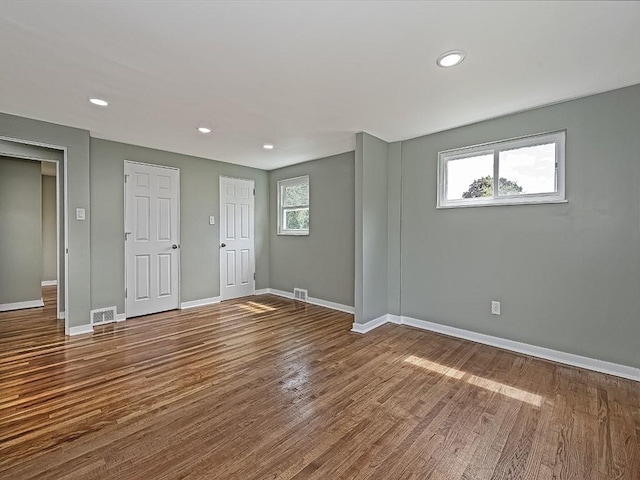 empty room with hardwood / wood-style floors and plenty of natural light