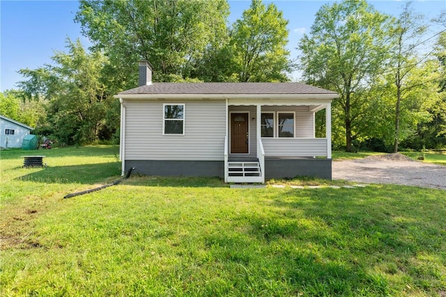 view of front of property featuring a chimney and a front yard