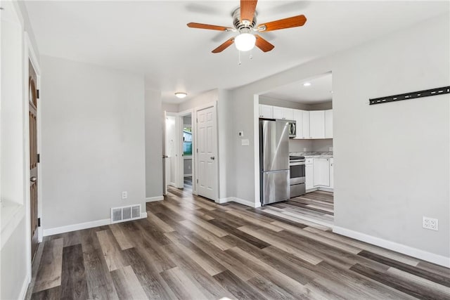 unfurnished living room featuring dark wood-style flooring, visible vents, ceiling fan, and baseboards