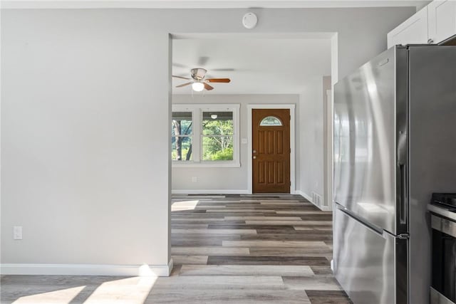 entryway featuring wood finished floors, a ceiling fan, and baseboards