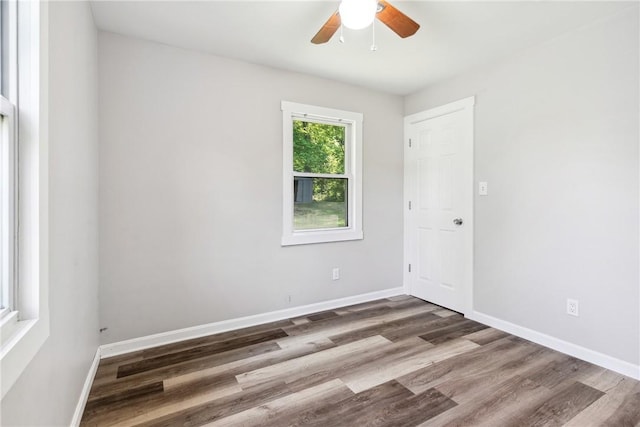 empty room featuring a ceiling fan, baseboards, and wood finished floors