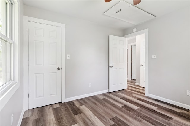 unfurnished bedroom featuring multiple windows, ceiling fan, and hardwood / wood-style floors