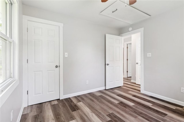 unfurnished bedroom featuring a ceiling fan, baseboards, and wood finished floors