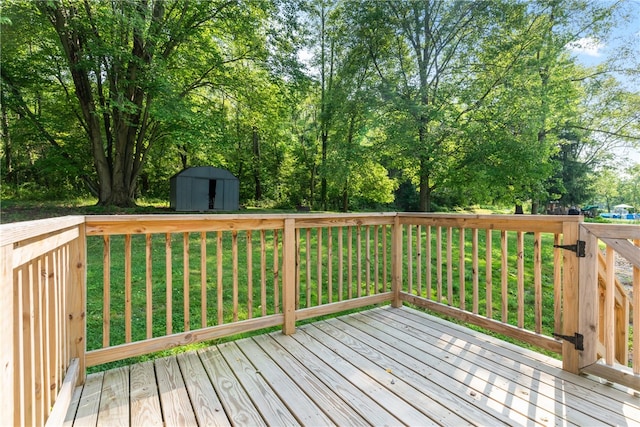 wooden terrace featuring a shed and a yard